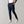 Donkerblauwe herenbroek, slim fit, gedragen met witte sneakers en een wit T-shirt. Stijlvolle casual outfit voor mannen.