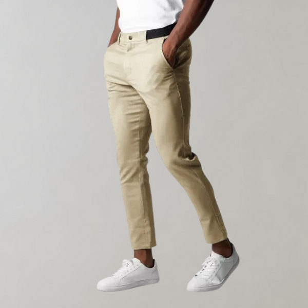 Khaki chino broek voor heren, gedragen met witte sneakers en een wit T-shirt. Stijlvolle casual outfit, ideaal voor dagelijks gebruik.