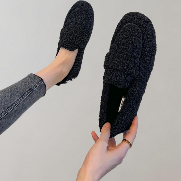 Zwarte, pluizige loafers voor dames, gedragen met grijze jeans. Comfortabele, stijlvolle schoenen voor dagelijks gebruik. Perfect voor casual outfits.