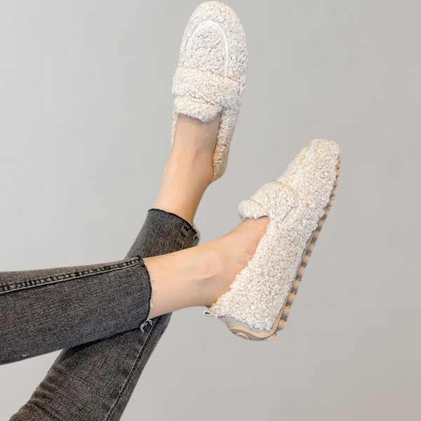 Witte dames loafers met schapenvacht textuur, gedragen met zwarte jeans. Comfortabele en stijlvolle schoenen voor dagelijks gebruik.
