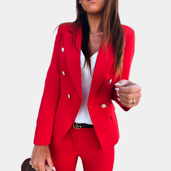 Vrouw in stijlvolle rode blazer en broek, witte top, met gouden knopen en zwarte riem. Modieuze dameskleding, zakelijke outfit.