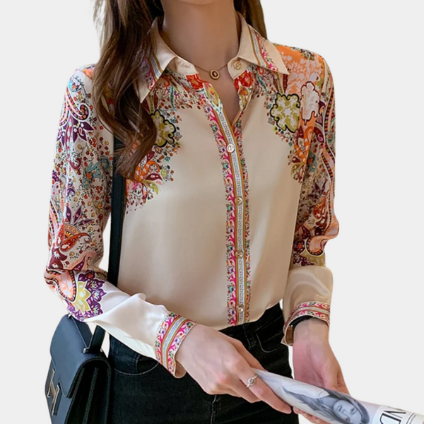 Vrouw in kleurrijke blouse met paisley-patroon, lange mouwen en kraag, houdt tijdschrift vast. Modieuze dameskleding, casual chique stijl.