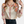 Vrouw draagt zijden blouse met kleurrijke bloemenprint en lange mouwen, gecombineerd met een zwarte broek. Modieuze dameskleding, elegant design.