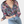 Vrouw in blauwe blouse met roze bloemenprint, opgerolde mouwen, gecombineerd met lichtblauwe jeans. Modieuze dameskleding, casual stijl.