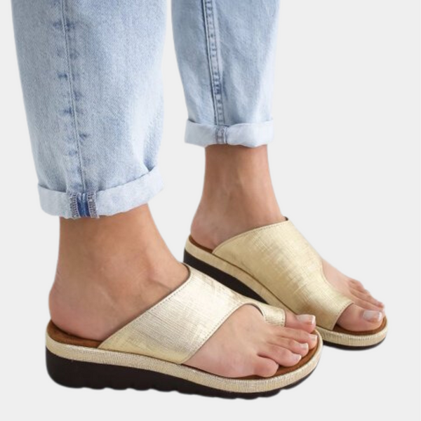 Gouden dames sandalen met dikke zool, gedragen met opgerolde lichte spijkerbroek. Comfortabele zomerschoenen, modieuze casual stijl.