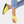 Gele dames sandalen met open teen en zwarte zool, gedragen met geborduurde jeans. Comfortabele zomerschoenen, modieus en casual.