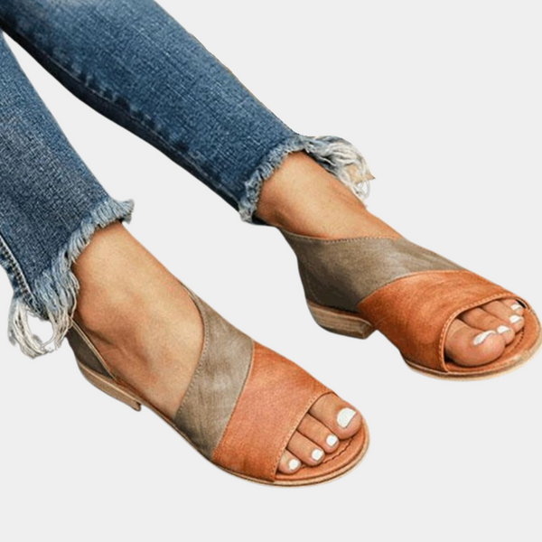 Bruin-oranje leren sandalen met open teen en lage hak, gedragen met gerafelde jeans. Stijlvolle damesmode, comfortabele zomerschoenen.