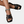 Zwarte leren sandalen met gevlochten bandjes en vierkante neus, gedragen met turquoise enkelbandje. Stijlvolle zomerschoenen voor dames.