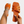 Oranje leren sandalen met gevlochten bandjes, gedragen aan een voet met enkelbandje. Trendy zomerschoen, damesmode, comfortabele pasvorm.