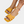 Gele dames sandalen met gevlochten bandjes, gedragen met een kleurrijke enkelband. Perfect voor zomerse outfits en strandmode.