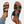Zwarte leren sandalen met bruine zool, gedragen door een persoon met jeans en enkelbandje. Stijlvolle zomerschoenen voor dames.
