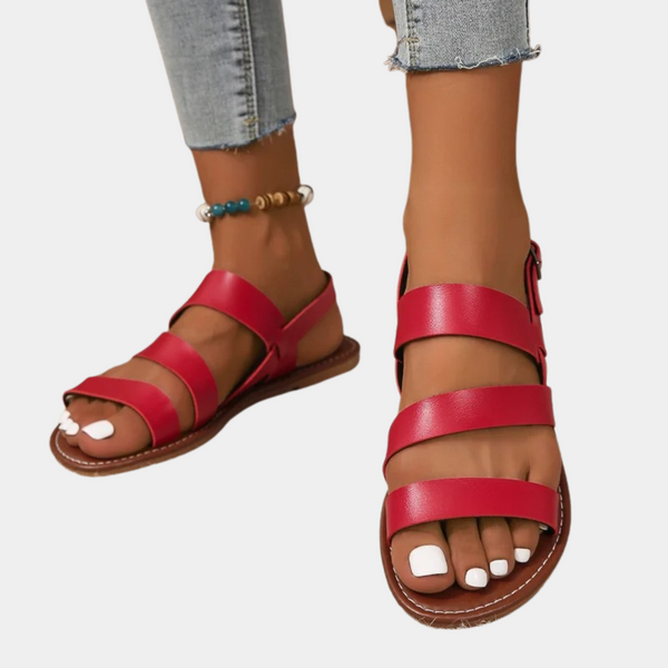 Rode leren sandalen met drie banden, gedragen met lichtblauwe jeans. Perfect voor zomermode en casual outfits. Comfortabele en stijlvolle dames sandalen.