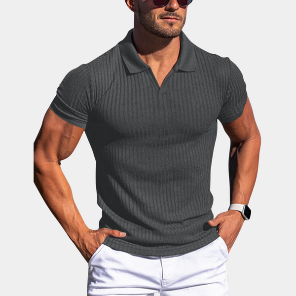 Donkergrijs geribd poloshirt voor heren, korte mouwen, gedragen door man met zonnebril en horloge. Stijlvolle casual herenkleding.