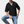 Zwarte herenpolo met korte mouwen en V-hals, gedragen door man met spijkerbroek. Moderne casual herenkleding, geschikt voor zomeroutfits.