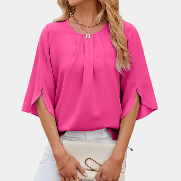 Vrouw in roze blouse met wijde mouwen, witte broek en beige clutch. Modieuze dameskleding, casual stijl, trendy outfit voor lente/zomer.