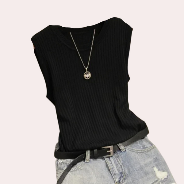 Zwarte geribbelde tanktop met ronde hals en zilveren ketting, gecombineerd met lichtblauwe gescheurde jeans en zwarte riem. Modieuze dameskleding.