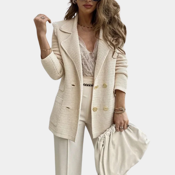 Vrouw in stijlvolle crèmekleurige blazer met dubbele knopen, kanten top en wijde broek. Modieuze outfit, perfect voor zakelijke of casual gelegenheden.