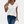 Vrouw draagt witte V-hals T-shirt en blauwe jeans, casual mode, dameskleding, trendy outfit, zomerse look, stijlvolle kledingcombinatie.