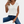Vrouw draagt witte V-hals T-shirt en blauwe jeans, modieuze casual outfit, minimalistisch design, comfortabele dameskleding, trendy stijl.