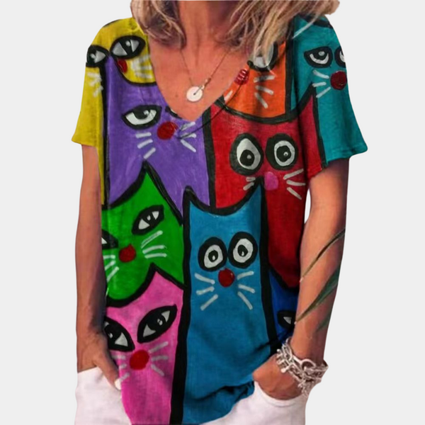 Vrouw draagt kleurrijk T-shirt met cartoon kattenprint, opvallende mode, casual dameskleding, trendy design, multicolor kattenmotief.