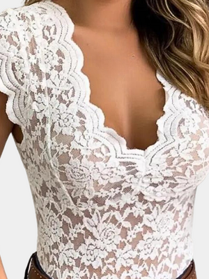 Vrouw draagt witte kanten top met bloemenpatroon en diepe V-hals, modieuze zomerkleding, elegante damesmode, trendy outfit.