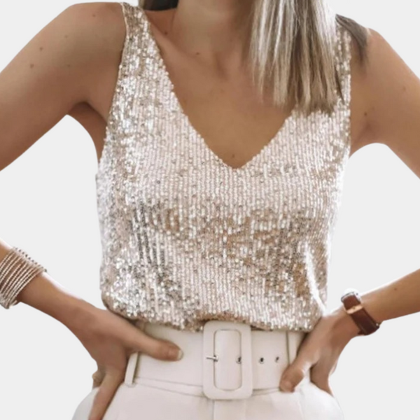 Vrouw in glinsterende pailletten top met V-hals, gecombineerd met witte broek en brede riem. Modieuze dameskleding, feestelijke outfit.