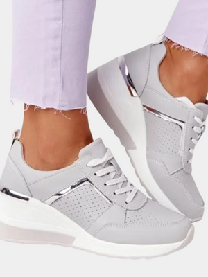 Witte dames sneakers met zilveren accenten, platformzool en perforaties. Modieuze en comfortabele schoenen voor dagelijks gebruik.