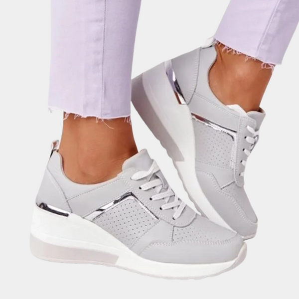 Witte dames sneakers met zilveren accenten, platformzool en perforaties. Modieuze en comfortabele schoenen voor dagelijks gebruik.
