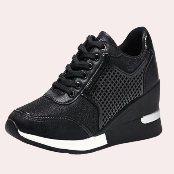 Zwarte damessneaker met sleehak, glanzend leer en gaasdetails. Comfortabele en modieuze schoenen, perfect voor dagelijks gebruik.