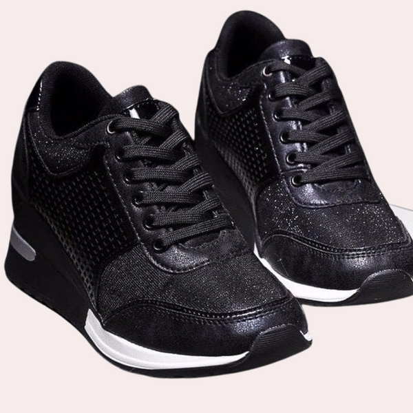Zwarte dames sneakers met glanzende afwerking, vetersluiting en witte zool. Modieuze en comfortabele schoenen voor dagelijks gebruik.