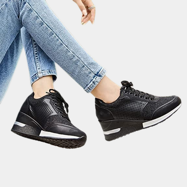 Zwarte dames sneakers met sleehak, geperforeerd leer, comfortabele pasvorm. Modieuze schoenen voor dagelijks gebruik. Perfect bij casual jeans.