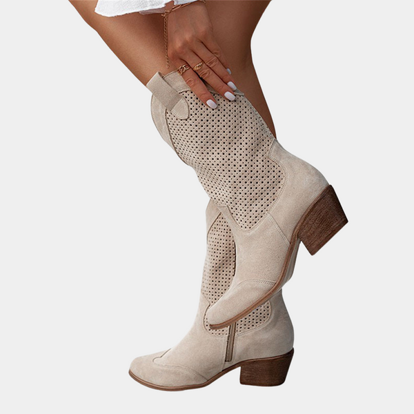 Beige suède cowboylaarzen met perforaties, blokhak en puntige neus. Trendy damesmode, perfect voor casual en chique outfits.