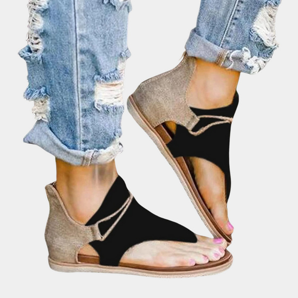 Zwarte sandalen met open teen en enkelband, gedragen met gescheurde jeans. Trendy zomerschoenen voor dames, casual en comfortabel.