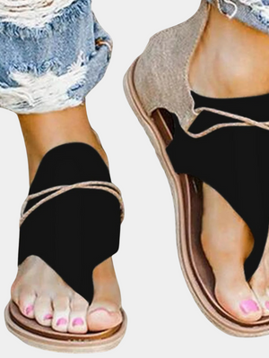 Zwarte sandalen met open teen en gevlochten bandjes, gedragen met gescheurde jeans. Trendy zomerschoenen voor dames, casual en stijlvol.