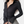 Zwarte ribgebreide blouse met lange mouwen en kraag, gedragen door model. Stijlvolle damesmode, perfect voor casual en zakelijke outfits.