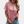Vrouw draagt roze T-shirt met knoopsluiting, korte mouwen en V-hals, gecombineerd met denim shorts. Modieuze casual dameskleding.
