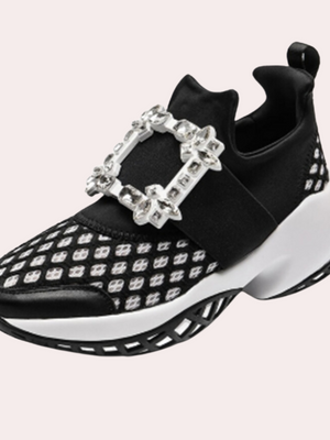 Zwarte sneaker met witte zool, diamantvormige gesp en patroon. Modieuze damesschoen, sportief en elegant. Geschikt voor casual en trendy outfits.