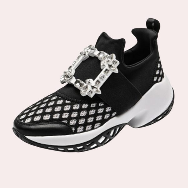 Zwarte sneaker met witte zool, diamantvormige gesp en patroon. Modieuze damesschoen, sportief en elegant. Geschikt voor casual en trendy outfits.