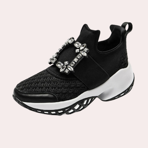 Zwarte sneaker met kristallen gesp, ademend mesh, en dikke witte zool. Modieuze damesschoen, ideaal voor casual en sportieve outfits.