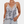 Vrouw in slangenprint top met kant, gouden kettingen en armbanden, lichtblauwe jeans. Modieuze dameskleding, trendy zomeroutfit.