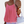Vrouw in roze chiffon top met dunne bandjes, witte tas en horloge. Modieuze zomerse outfit, casual stijl.