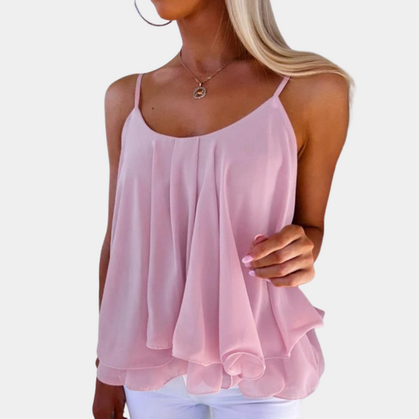Lichtroze dames top met spaghettibandjes, luchtige stof en vloeiende plooien, ideaal voor zomermode. Perfecte casual outfit voor warme dagen.