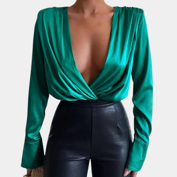 Groene satijnen blouse met diepe V-hals en lange mouwen, gecombineerd met zwarte leren broek. Elegante damesmode, trendy outfit.