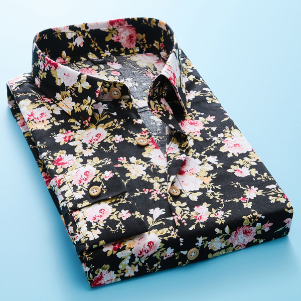 Zwarte bloemenoverhemd met roze en witte bloemenprint, opgevouwen op een blauwe achtergrond. Stijlvol herenmode item, perfect voor casual en formele gelegenheden.