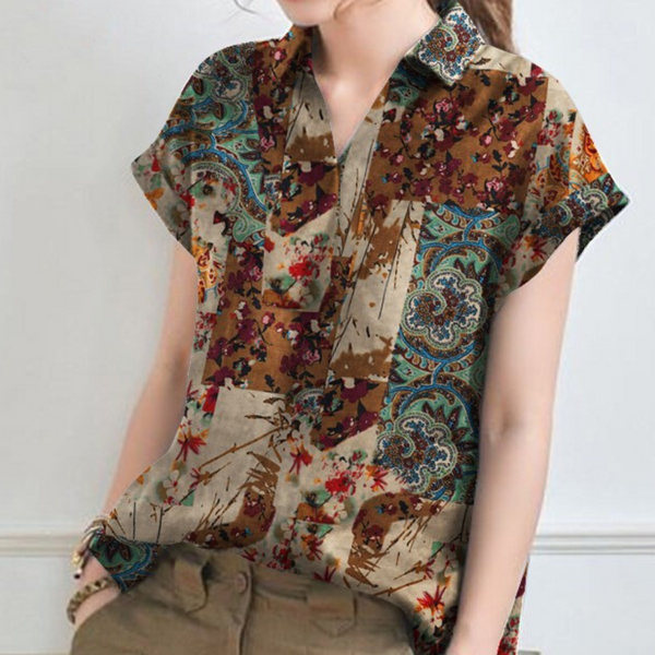 Vrouw draagt kleurrijke blouse met bloemen- en paisleypatroon, korte mouwen en kraag. Modieuze dameskleding, casual stijl, boho chic.