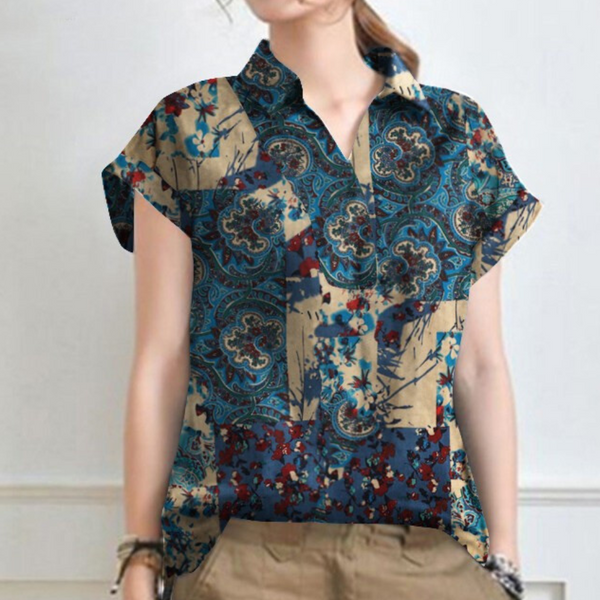 Vrouw draagt blauwe blouse met bloemenprint en korte mouwen, gecombineerd met beige broek. Modieuze dameskleding, casual stijl.