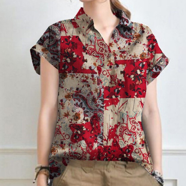 Vrouw draagt een kleurrijke blouse met rood bloemen- en paisleypatroon, korte mouwen en kraag. Modieuze dameskleding, casual stijl.