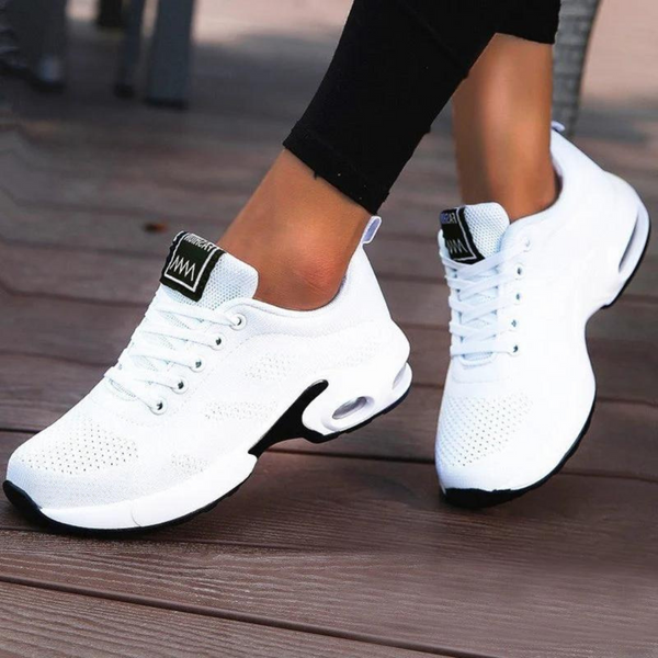Witte dames sneakers met ademend mesh, comfortabele zool en zwarte accenten. Perfect voor sport en casual outfits. Trendy en veelzijdig schoeisel.
