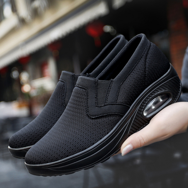 Zwarte dames sneakers met ademend mesh, slip-on design en verhoogde zool. Comfortabele schoenen voor dagelijks gebruik en wandelen.