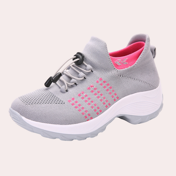 Grijze dames sneaker met roze accenten, ademend mesh, elastische vetersluiting, comfortabele zool. Perfect voor sport en dagelijks gebruik.